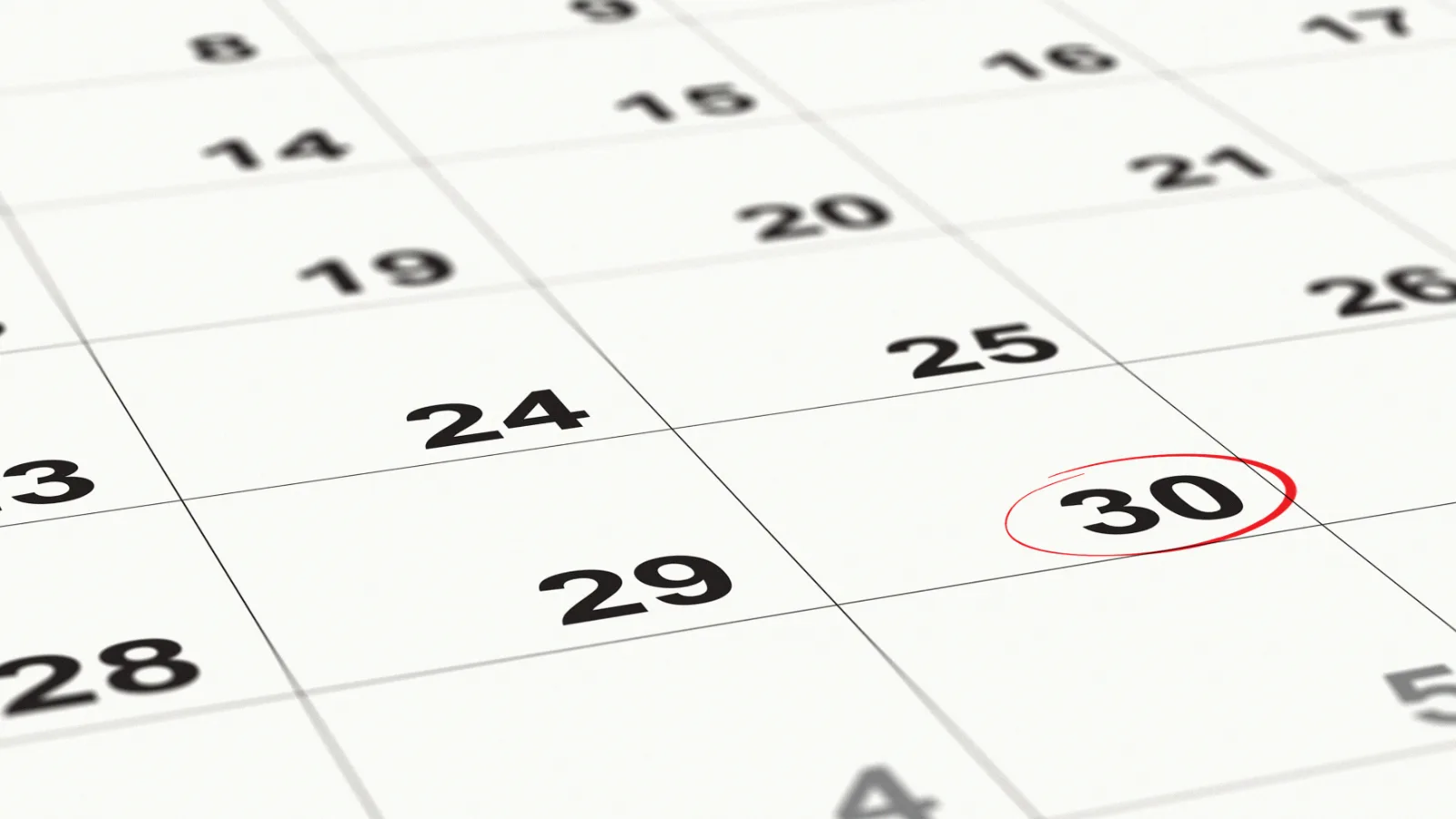 Close-up of a calendar page with a date circled in red, marking a deadline